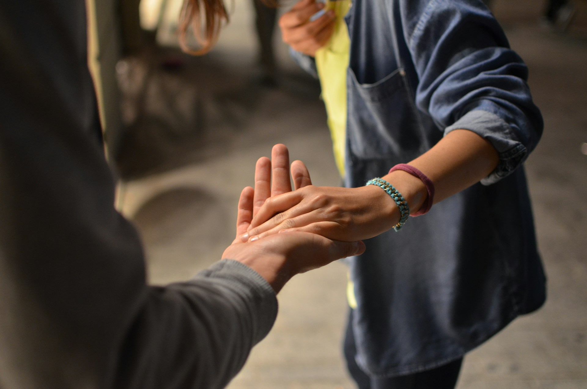 Two people reaching out to hold hands in a gesture of support